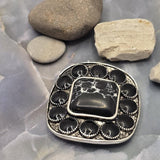 Antique silver western slider bead with a large faux marble center stone and decorative border of oval black stones. The substantial size makes it ideal as a centerpiece in jewelry designs. A dime demonstrates scale, while dual holes allow secure placement in multi-strand projects. Perfect for handmade bracelets, western necklaces, leather jewelry, custom beadwork, and artisan-crafted statement accessories.