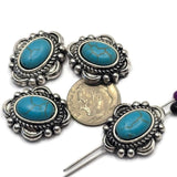 Antique silver 2 Hole Slider Beads featuring oval faux turquoise center stones surrounded by decorative western-inspired metalwork. The dual-hole construction supports multi-strand jewelry projects while the bold turquoise color creates a striking focal point. Displayed with a dime for scale, these beads work beautifully in bracelets, necklaces, beadwork, leather jewelry, and artisan-crafted accessories.