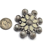 Oversized circular focal bead adorned with cream and white enamel details surrounded by decorative antique silver metalwork. The floral-inspired starburst design creates a striking centerpiece for jewelry creations. Shown beside a dime for scale, this dual-hole slider bead works beautifully in handmade bracelets, necklaces, leather jewelry, custom accessories, and western-inspired statement jewelry projects.