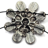 Large antique silver focal bead with cream and white enamel accents arranged around a decorative center. The western-inspired design combines neutral colors with intricate metalwork for a timeless appearance. Shown with a dime for scale, this statement slider bead is excellent for handmade jewelry, leather jewelry, beadwork projects, and Southwestern-inspired accessories.