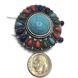 Large round focal bead with a faux turquoise center stone displaying natural-looking veining and surrounded by colorful teardrop-shaped faux stone accents. The antique silver setting adds texture and western character throughout the design. Photographed on a decorative background, this oversized slider bead is ideal for statement bracelets, necklaces, leather jewelry, artisan accessories, and handcrafted Southwestern jewelry.
