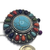 Statement western-style focal bead featuring a large faux turquoise center stone and colorful surrounding accents in coral orange, olive green, turquoise blue, deep blue, and purple. The antique silver setting showcases intricate detailing and dimensional texture. Ideal for handmade bracelets, necklaces, artisan beadwork, leather jewelry, and unique one-of-a-kind jewelry creations.