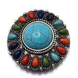 Decorative oversized 2 Hole Slider Bead with a faux turquoise center stone framed by colorful faux stone accents in multiple vibrant shades. The antique silver setting includes rope detailing and raised accents that enhance the western styling. Displayed on a hand for scale, this focal bead is perfect for artisan jewelry, statement necklaces, bracelets, and Southwestern-inspired creations.