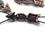 Arrow-inspired focal beads featuring bright faux turquoise stones and warm antique copper finishes. The elongated shape provides a distinctive centerpiece for jewelry designs while maintaining a classic western appearance. Photographed with a dime for scale, these beads are perfect for handmade bracelets, necklaces, artisan accessories, and rustic jewelry collections.