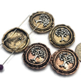 Decorative Tree of Life focal beads with detailed raised tree designs in antique copper and light antique gold settings. Their dual-hole construction helps maintain strand alignment in multi-strand jewelry. Perfect for handmade bracelets, necklaces, memorial jewelry, inspirational accessories, family-themed designs, and artisan jewelry collections.