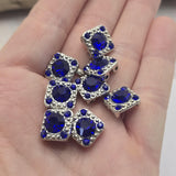 These decorative Rhinestone Slider Beads feature brilliant Sapphire Blue stones set within detailed antique silver frames. The two-hole design allows them to function beautifully as focal beads in bracelets, necklaces, pendants, and multi-strand jewelry. Their compact size and versatile styling make them excellent choices for bead weaving, loom work, Peyote Stitch projects, and a wide variety of handmade jewelry applications.