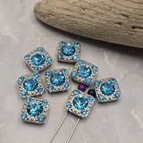 Create eye-catching jewelry with these Aquamarine Rhinestone Slider Beads. The brilliant faceted center stone is surrounded by coordinating accent rhinestones that add sparkle from every angle. Designed with two holes for stringing, these focal beads work beautifully in bracelet making, necklace designs, multi-strand jewelry, bead weaving, and artisan jewelry projects. Their platinum silver finish provides a clean, elegant appearance suitable for countless handmade creations.