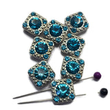 These beautiful Aquamarine Slider Beads feature sparkling aqua-blue rhinestones set in a bright platinum silver finish. The square design and dual-hole construction make them perfect focal beads for bracelets, necklaces, leather jewelry, earrings, and pendants. Their vibrant color pairs beautifully with silver findings and seed beads, while the versatile design makes them suitable for bead weaving, loom work, and custom handmade jewelry projects.