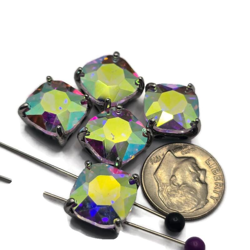 Add dramatic sparkle to your jewelry designs with these Large Clear AB CZ Rhinestone 2 Hole Slider Beads. Featuring oversized faceted rhinestones in a platinum silver setting, these focal beads display flashes of yellow, pink, blue, lavender, and green as they catch the light. Perfect for bracelet making, necklace designs, pendants, earrings, and multi-strand jewelry, they create stunning centerpieces in handmade jewelry and bead weaving projects.