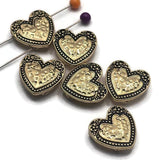 These bright gold 2 Hole Slider Beads with antique detailing feature a beautifully textured heart centerpiece surrounded by decorative floral accents and a beaded border. Perfect as focal beads for bracelet making, necklace designs, earrings, and pendants, their dual-hole construction keeps multi-strand jewelry aligned while adding warmth and vintage-inspired charm. A wonderful addition to jewelry making supplies for romantic, Western, and artisan handmade jewelry.