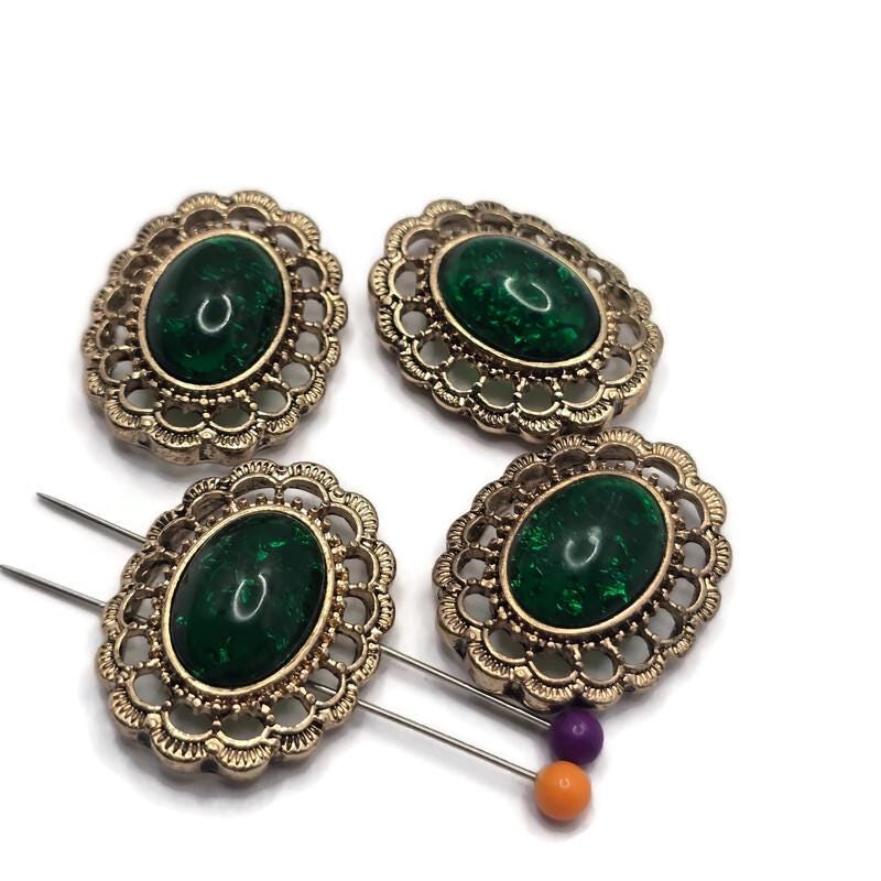 Create elegant handmade jewelry with these Emerald Green Oval 2 Hole Slider Beads featuring a rich emerald cabochon set in an ornate antique gold filigree frame. These beautiful focal beads are perfect for bracelets, necklaces, and multi-strand designs. Their two-hole construction keeps strands aligned while adding a timeless vintage look that pairs beautifully with pearls, crystals, gemstones, and other jewelry making supplies.
