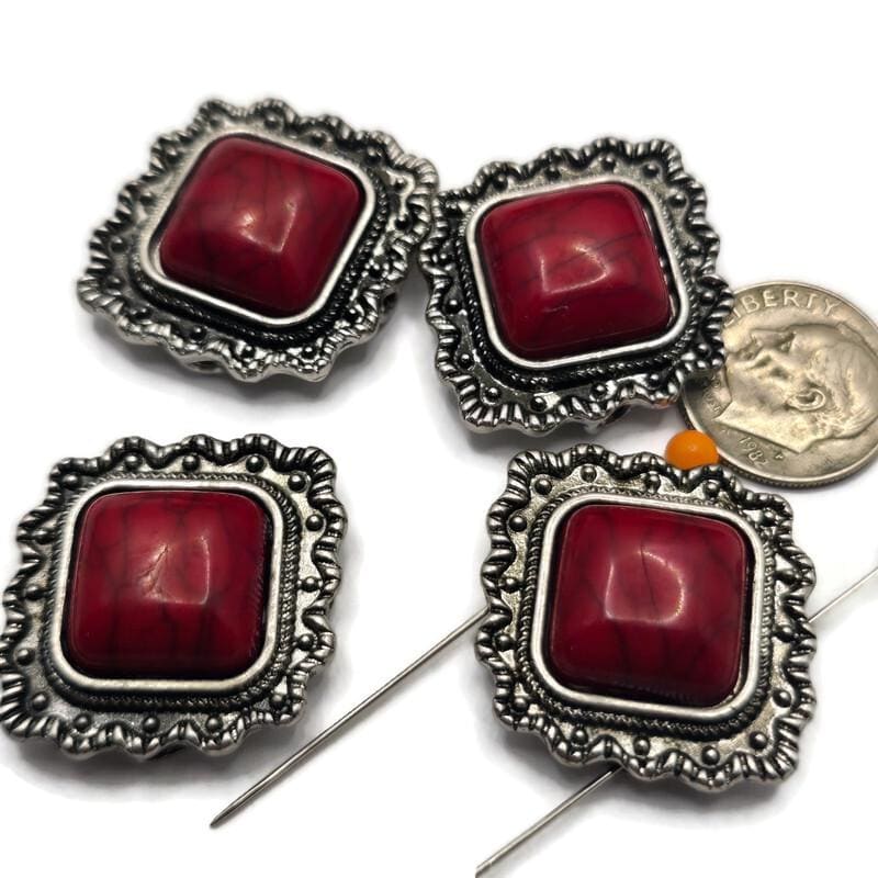 These Western 2 Hole Slider Beads feature faux red turquoise centers surrounded by ornate antique silver metal frames. Perfect as focal beads for bracelets, necklaces, and multi-strand jewelry, their bold square shape brings classic Southwestern style to handmade designs. Pair these decorative metal beads with leather, seed beads, jasper, howlite, or other jewelry making supplies to create rustic Western and cowgirl-inspired jewelry.