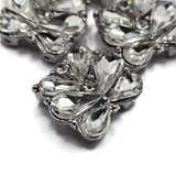 These platinum silver 2 hole slider beads feature an elaborate arrangement of high-quality clear rhinestones for incredible sparkle and dimension. Large faceted teardrop crystals form a floral-inspired design while smaller round rhinestones add extra brilliance between the stones. Each bead measures approximately 17 mm wide by 20 mm tall. Use these crystal focal beads for double strand bracelets, bead weaving, necklaces, bridal jewelry,  and sparkling handmade jewelry. Package includes 5 beads.