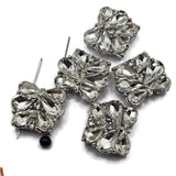 Design sparkling handmade jewelry with these clear crystal floral 2 hole slider beads in a platinum silver or stainless steel-tone metal setting. Large faceted teardrop rhinestones reflect light beautifully while smaller round crystals add additional sparkle throughout the design. Each focal bead measures approximately 17 mm wide by 20 mm tall. Use them for DIY bracelets, double strand jewelry, bead weaving, necklaces, bridal accessories, prom jewelry, and elegant statement pieces.