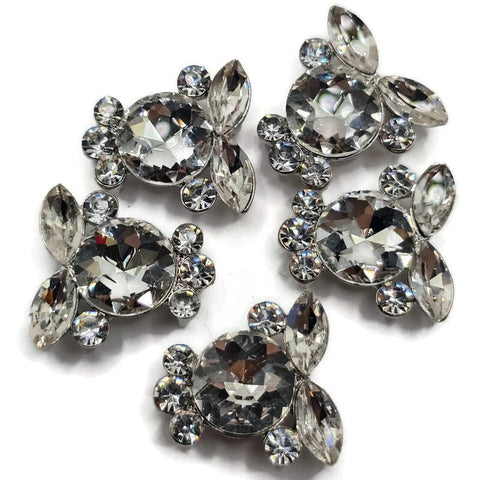 Clear rhinestone 2 hole slider beads in a bright platinum silver metal tone featuring a large faceted round crystal surrounded by marquise and smaller round rhinestones. These sparkling focal beads are beautiful for double strand bracelets, bead weaving, necklaces, bridal jewelry, seed bead designs, and DIY jewelry making. The dimensional crystal cluster design adds brilliant sparkle and an elegant statement look to handmade jewelry projects.