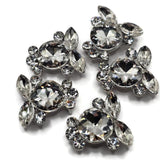 Platinum silver crystal focal beads featuring large faceted clear round rhinestones surrounded by sparkling marquise and smaller round stones. These ornate 2 hole slider beads create a beautiful statement in bracelets, necklaces, bead weaving, and multi-strand jewelry designs. Perfect for bridal jewelry, prom accessories, pageant jewelry, formal designs, and glamorous handmade pieces, the clear rhinestones coordinate easily with pearls, seed beads, gemstones, and colorful crystals.