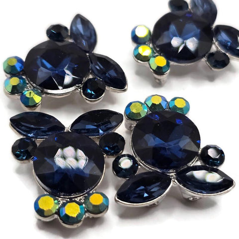 Montana Blue rhinestone 2 hole slider beads featuring deep navy blue faceted crystals with sparkling Clear AB accents in a platinum silver setting. These crystal focal beads are perfect for double strand bracelets, bead weaving, seed bead jewelry, necklaces, and multi-strand designs. Hidden loops on the back provide easy stringing while the dimensional rhinestone surface adds brilliant sparkle to DIY jewelry making and handmade statement jewelry.