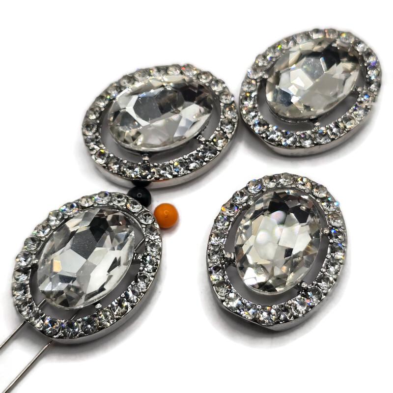 Large clear rhinestone 2 hole slider beads featuring a brilliant faceted glass center stone surrounded by sparkling clear crystal rhinestones in a platinum silver metal tone setting. These elegant oval focal beads are perfect for bridal jewelry, wedding bracelets, statement necklaces, double strand bracelets, bead weaving, and handmade jewelry designs. Beautiful jewelry making supplies for creating glamorous crystal jewelry with exceptional sparkle and a polished boutique-quality appearance.