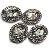Oversized clear rhinestone 2 hole slider beads designed to create dramatic focal points in handmade jewelry. A large faceted oval glass crystal is surrounded by a sparkling halo of smaller clear rhinestones in a platinum silver setting. Perfect for bridal bracelets, wedding jewelry, formal necklaces, double strand bracelets, multi-strand jewelry, bead weaving, and DIY jewelry making. These crystal focal beads bring brilliant sparkle and elegant dimension to statement jewelry designs.