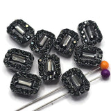 These jet and hematite rhinestone 2 hole slider beads feature a faceted rectangular center surrounded by sparkling coordinating crystals in a dark gunmetal setting. The combination of smoky gray, black, and metallic tones creates sophisticated sparkle without bright color. Perfect for double strand bracelets, bead weaving, necklaces, and statement jewelry, these crystal focal beads pair beautifully with black beads, gemstones, seed beads, silver accents, and other jewelry making supplies.