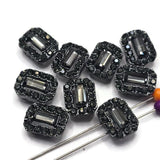 Create sophisticated handmade jewelry with these jet and hematite rhinestone 2 hole slider beads. The rectangular focal design features a large faceted center crystal surrounded by smaller sparkling rhinestones, all set in coordinating gunmetal metal. These dark crystal beads are ideal for double strand bracelets, statement jewelry, bead weaving, and necklace designs. Pair them with black, gray, silver, jewel tones, gemstones, crystals, or seed beads for dramatic jewelry making projects.