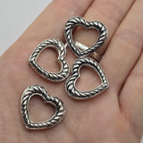 Silver heart 2 hole slider bead featuring an open center, raised rope pattern, and antique detailing. Versatile jewelry making focal bead with hidden stringing loops for bracelets, bead weaving, Western jewelry, boho designs, and handmade jewelry projects.