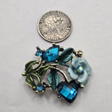 Create colorful handmade jewelry with these antique gold floral 2 hole slider beads featuring sparkling Blue Zircon crystals and blue enamel botanical details. Sculpted flowers, vines, and teal green leaves give these focal beads beautiful dimension for statement bracelets, necklaces, bead weaving, and multi-strand jewelry. Perfect for bohemian, cottagecore, garden-inspired, and romantic jewelry designs. Approximately 12 mm between the stringing loops.