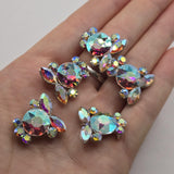 Platinum silver Clear AB rhinestone slider beads featuring large faceted center crystals with marquise and round crystal accents. The Aurora Borealis finish reflects shifting shades of turquoise, pink, purple, green, blue, and gold for incredible sparkle. These 2 hole focal beads make beautiful jewelry making supplies for double strand bracelets, necklaces, bead weaving, bridal jewelry, seed bead designs, pageant accessories, and glamorous handmade jewelry.