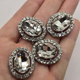 Glamorous clear rhinestone 2 hole slider beads with a large oval faceted glass crystal centerpiece and a complete halo of smaller clear rhinestones. Set in platinum silver metal tone, these statement focal beads are beautiful for bridal jewelry, wedding bracelets, formal necklaces, bead weaving, double strand bracelets, and handmade jewelry designs. Their sparkling clear crystal palette makes them versatile jewelry making supplies for elegant vintage-inspired, or special occasion jewelry.