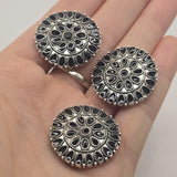 Oversized round western-style focal bead with black enamel and detailed antique platinum silver metalwork. This decorative 2 hole slider bead has an intricate medallion pattern that makes a dramatic centerpiece for western bracelets, statement jewelry, hat bands, bead weaving, and artisan jewelry designs.