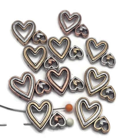 Mixed metal 2 hole slider bead featuring a large open heart with a smaller heart beside it in contrasting soft gold and silver finishes. This double-heart focal bead is ideal for handmade bracelets, necklaces, bead weaving, romantic jewelry, and multi-strand designs.