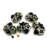 Antique gold floral 2 hole slider beads feature faceted jet black rhinestones, green and gray enamel accents, and beautifully detailed dimensional flowers and leaves. These dramatic focal beads are perfect for bracelets, necklaces, bead weaving, and multi-strand jewelry designs. The two-hole construction helps keep strands aligned while adding a professional finished look. Each bead measures approximately 30 mm x 21 mm with 12 mm between the loops. Five beads per package.