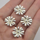 Decorative white enamel flower beads in bright silver plated metal featuring two holes for jewelry making. These 17 mm floral slider beads have alternating white and polished silver petals surrounding a dimensional center. With approximately 5 mm between the stringing holes, these focal beads work beautifully in beaded bracelets, double-strand jewelry, bead weaving, necklaces, bridal designs, floral jewelry, and handmade accessories.