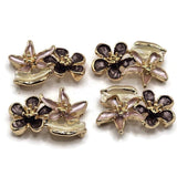 Bright gold floral 2 hole slider beads featuring dimensional pink, plum, and creamy ivory enamel flowers with sculpted botanical details. Each 26 mm focal bead combines two different flower shapes and a decorative leaf for a layered garden-inspired appearance. Two stringing holes approximately 7.5 mm apart make these jewelry components ideal for double-strand bracelets, bead weaving, necklaces, cuffs, and handmade jewelry designs.