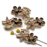 Botanical 2 hole slider beads featuring dimensional enamel flowers and leaves in a warm bright gold metal finish. Soft blush pink petals, rich plum flowers, and creamy ivory leaves create an elegant floral arrangement on each 26 mm focal bead. Two holes spaced approximately 7.5 mm apart provide versatile stringing options for double-strand bracelets, necklaces, bead weaving, cuffs, and garden-inspired handmade jewelry.