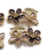 Pink, plum, and ivory enamel floral slider beads set in polished bright gold plated metal for jewelry making. Each 26 mm 2 hole focal bead resembles a miniature flower arrangement with two dimensional blooms and a decorative leaf. The dual-hole construction helps maintain strand spacing in double-strand bracelets, bead weaving, multi-strand necklaces, floral accessories, garden-inspired jewelry, handmade gifts, and feminine jewelry designs.
