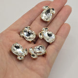 Decorative Clear crystal slider beads with brilliant faceted rhinestones set in bright gold plated base metal. These 20 mm by 16 mm statement focal beads have two hidden stringing loops approximately 9 mm apart on the back. Versatile jewelry-making components for beaded bracelets, multi-strand necklaces, bead weaving, wedding jewelry, formal accessories, handmade gifts, and sophisticated gold and crystal jewelry designs.