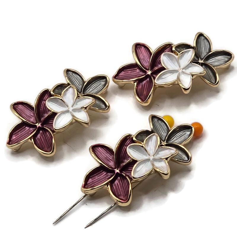 Bright gold floral 2 hole slider beads featuring three connected enamel flowers in rich plum, pearly white, and smoky gray. Each large 37.5 mm focal bead has sculpted five-petal flowers with polished gold outlines and textured enamel detailing. Two stringing holes approximately 10 mm apart make these statement jewelry components ideal for double-strand bracelets, bead weaving, necklaces, cuffs, and botanical jewelry designs.