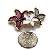 Multicolor enamel flower slider beads in polished bright gold plated metal for handmade jewelry making. Each 37.5 mm statement focal features three connected flowers in deep plum, luminous white, and smoky gray enamel. Gold outlines emphasize the individual petals and dimensional floral design. These 2 hole jewelry components are beautiful for beaded bracelets, multi-strand designs, necklaces, bead weaving, floral jewelry, and handmade accessories.