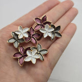 Bright gold enamel floral focal beads featuring three dimensional flowers in coordinating plum, pearly white, and smoky gray colors. These elongated 2 hole slider beads measure approximately 37.5 mm long and 21 mm wide, creating substantial statement components for handmade jewelry. Use these botanical beads for double-strand bracelets, necklaces, bead weaving, multi-strand designs, cuffs, romantic floral jewelry, and elegant DIY beading projects.
