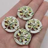 Elegant light green Tree of Life jewelry making beads featuring polished gold branches and decorative enamel leaves in soft sage, mint green, seafoam, lime, and white. These beautiful round 2 Hole Slider Beads feature textured circular borders in complementary pale green and pearly white finishes. Ideal jewelry findings for bracelet making, necklace designs, inspirational jewelry, and handmade accessories. Unique focal beads for creating spring jewelry, botanical designs, and thoughtful gifts.