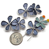 Beautiful Blue Flower 2 Hole Slider Beads featuring three overlapping enamel flowers in rich slate blue, smoky denim blue, and soft aqua colors. The predominantly dark blue floral design includes a contrasting aqua accent flower with bright reflective silver outlines and delicate raised centers. These decorative jewelry focal beads are perfect for handmade bracelets, necklace designs, multi-strand jewelry, and bead weaving projects. Unique jewelry making supplies for elegant floral accessories.