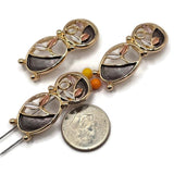 Stunning bright gold abstract floral slider beads featuring a graceful arrangement of openwork oval shapes, delicate enamel leaves, and contrasting charcoal gray, champagne, and ivory accents. The reflective gold outlines and softly textured enamel create beautiful depth and dimension in these decorative jewelry components. Ideal 2 Hole Slider Beads for handmade bracelets, necklaces, earrings, bead weaving, and artisan jewelry projects.
