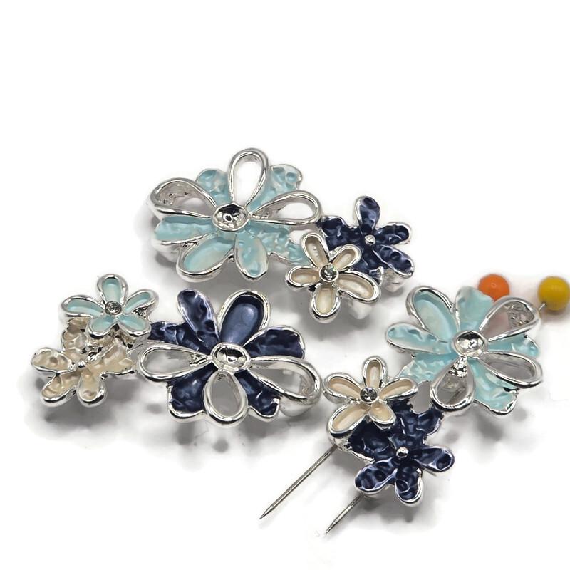 Stunning bright silver Flower Slider Beads showcasing an artistic arrangement of overlapping blossoms in pale aqua blue, deep midnight blue, and luminous ivory enamel. Each decorative jewelry component features dimensional flower petals, polished silver outlines, and delicate openwork metallic accents. These unique 2 Hole Slider Beads are perfect for handmade bracelets, beaded necklaces, multi-strand jewelry, and creative bead weaving.