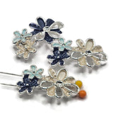 Beautiful bright silver floral 2 Hole Slider Beads featuring overlapping flowers in creamy ivory, dark navy blue, and soft light aqua enamel. Each decorative focal bead showcases dimensional blossoms with textured petals, polished silver outlines, and delicate openwork flower details. These unique jewelry-making components are perfect for handmade bracelets, necklaces, bead weaving, and multi-strand jewelry.