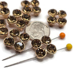 Bright gold smoked topaz rhinestone 2 hole slider beads featuring four round, faceted smoky brown rhinestones arranged in a dimensional square floral-inspired design. Each decorative focal bead showcases rich golden-brown stones surrounded by polished bright gold settings. Beautiful jewelry-making components for handmade bracelets, necklaces, bead weaving, and elegant multi-strand jewelry designs.