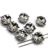 Round clear rhinestone slider beads measuring approximately 12 mm in diameter with 5 mm between the side-drilled holes. Each decorative bead features a large faceted clear stone in a polished platinum silver setting with four small raised accents. Seven beads per package for handmade jewelry, double-strand bracelets, necklaces, bead weaving, and decorative cuffs.