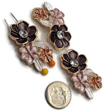 Bright gold black, pink, and peach enamel floral slider beads displayed beside a US dime for size comparison. Each decorative 2 hole jewelry-making bead measures approximately 32 mm wide and 19 mm tall with 8 mm between the holes. The dimensional flower arrangement features a sparkling clear rhinestone center, pastel enamel flowers, and pearl white leaves, ideal for bracelets, necklaces, and bead weaving.