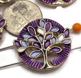 Decorative Tree of Life focal beads with intricate bright reflective gold branches and colorful enamel leaves in purple, lavender, blue, and white. These beautiful round 2 Hole Slider Beads offer a unique combination of symbolic design and vibrant color. Perfect for bracelet making, necklace designs, beaded jewelry, and nature-inspired accessories. Versatile jewelry findings for handmade gifts, boutique jewelry collections, bead weaving tutorials, and creative jewelry making projects.