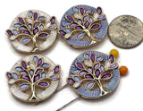 Beautiful gold Tree of Life 2 Hole Slider Beads with colorful purple and blue enamel leaves, delicate openwork branches, and textured circular borders. These eye-catching jewelry focal beads feature two complementary color combinations with pearly white and soft blue backgrounds. Ideal for handmade jewelry designs, multi-strand bracelets, necklaces, earrings, and bead weaving projects. Unique jewelry making components for creating meaningful, colorful, and handmade jewelry accessories.